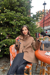 a lady in a tencel wool coat and a pair of black pants
